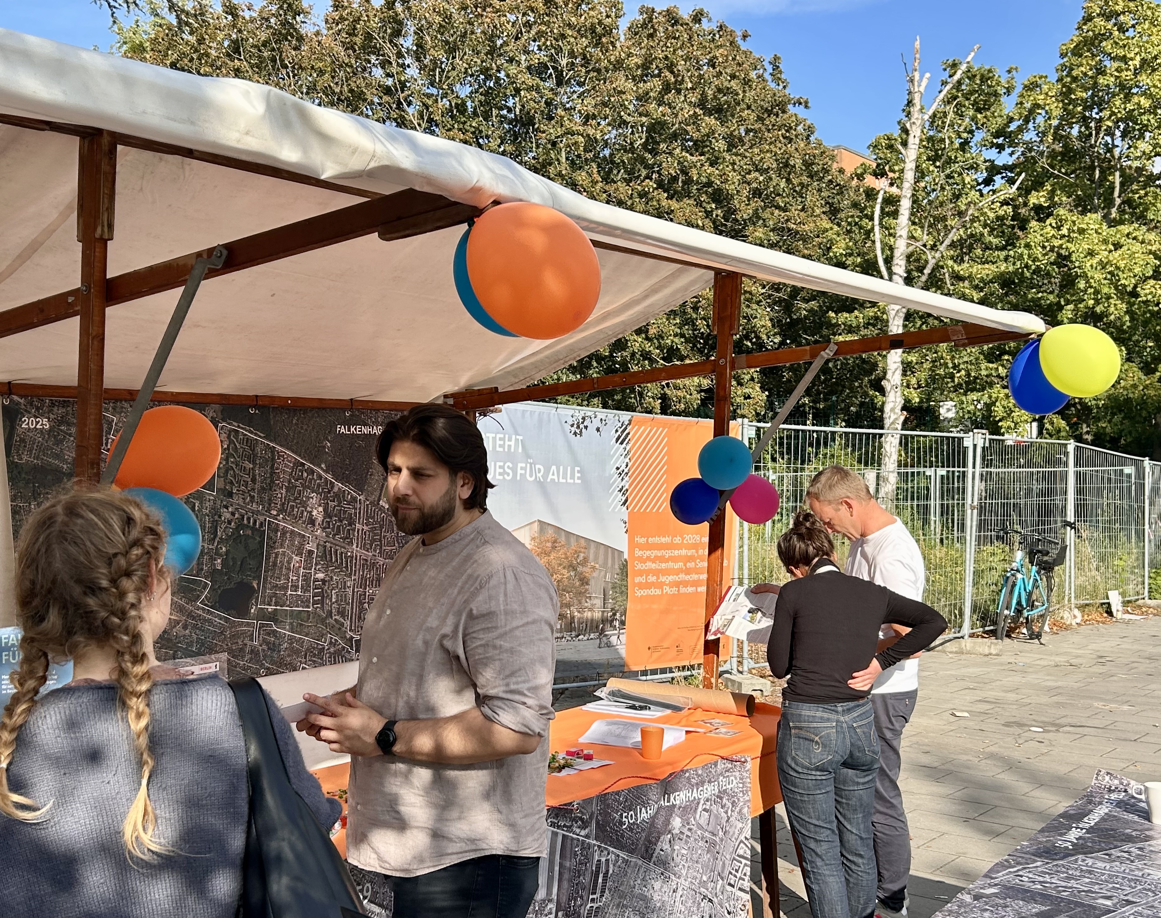 Personen Informieren sich an einen Infostand über das Gebiet